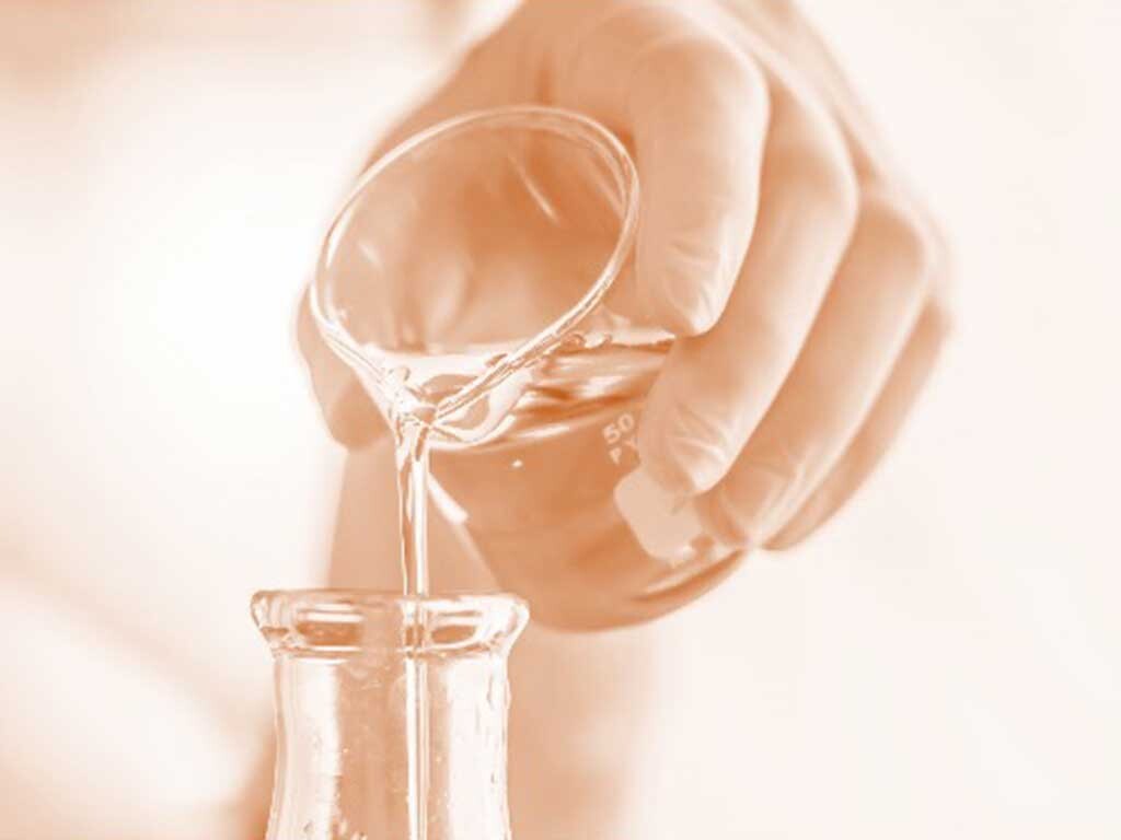Scientist pouring beaker